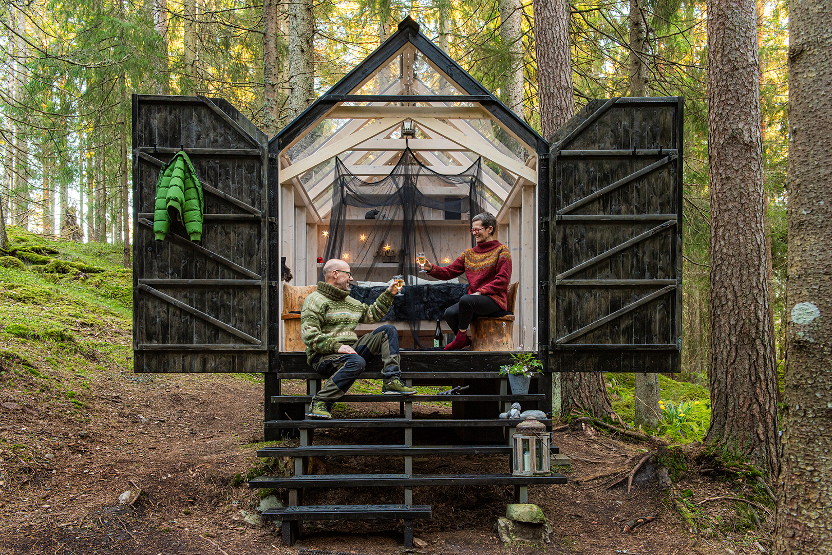 Glashus-glamping i fridfull skog vid en sjö